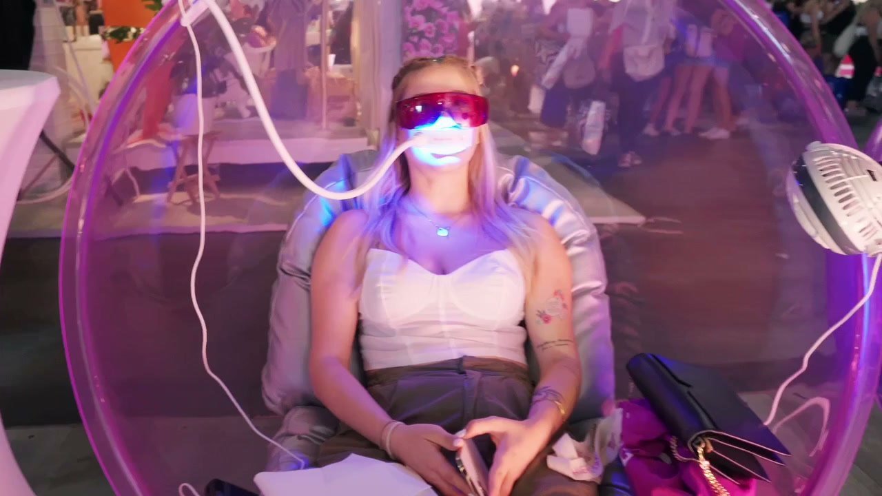 Cliente installée dans le fauteuil-bulle OnlySmile pendant sa séance de blanchiment à la lampe LED